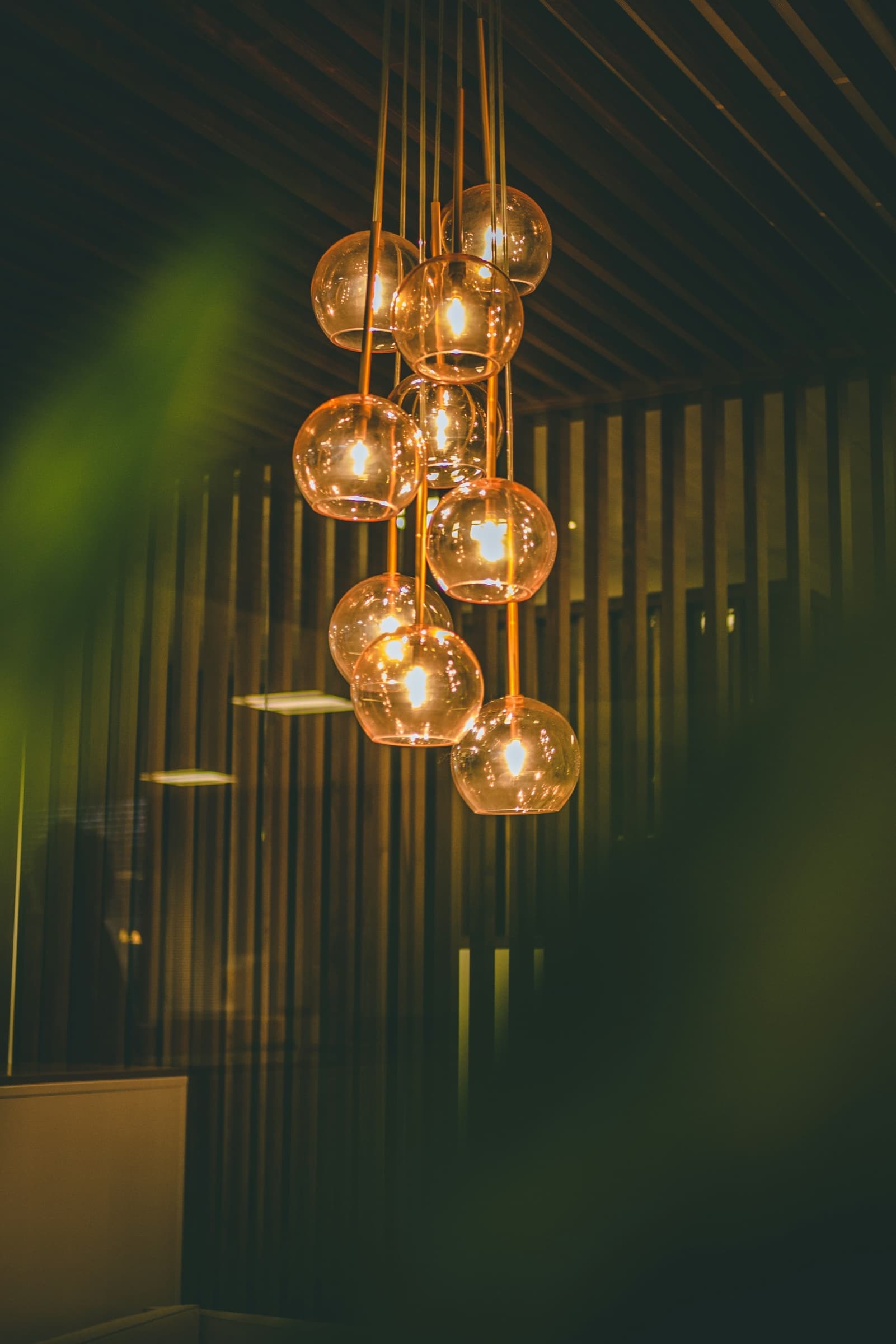 A cluster of amber glass pendant lights glowing warmly against a dark interior